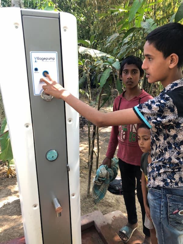 Children at a solar-powered Villagepump in Bangladesh pressing the start button